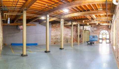 a large room with a brick wall and wooden ceilings