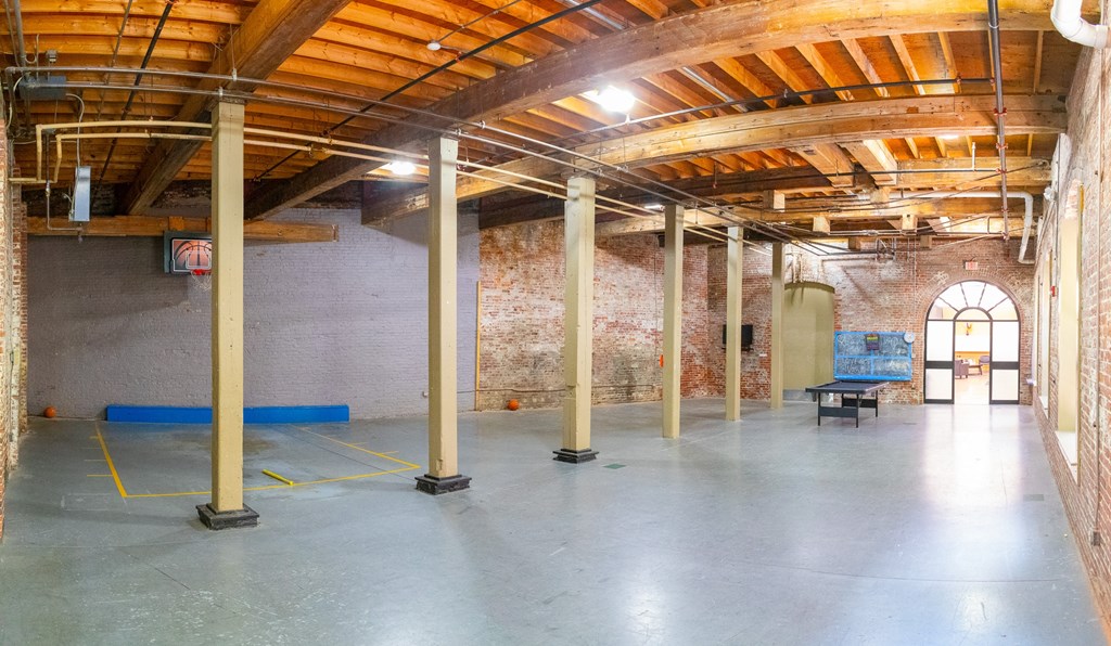 a large room with a brick wall and wooden ceilings