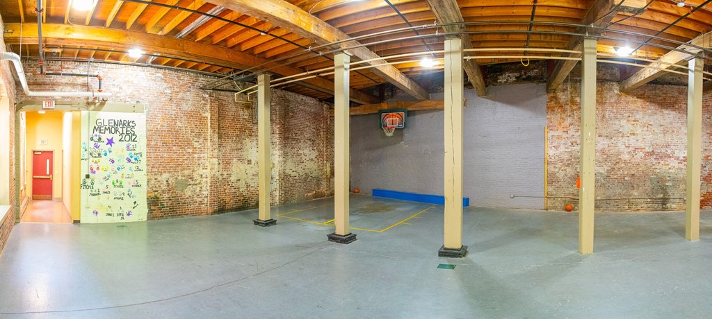 a large room with a brick wall and wooden ceilings