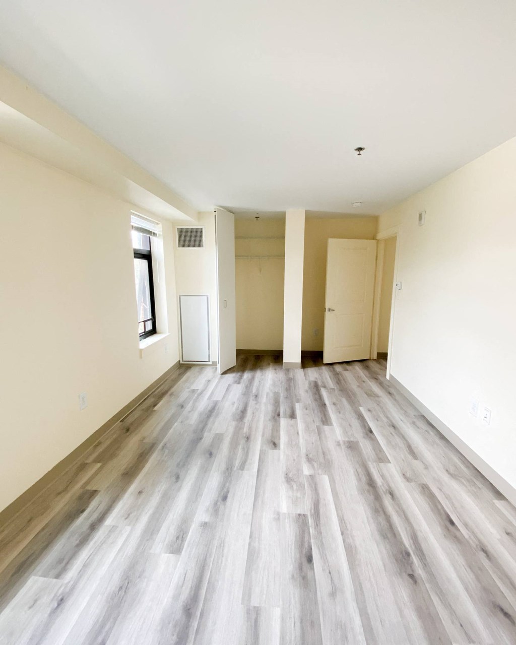 an empty living room with wood floors and white walls