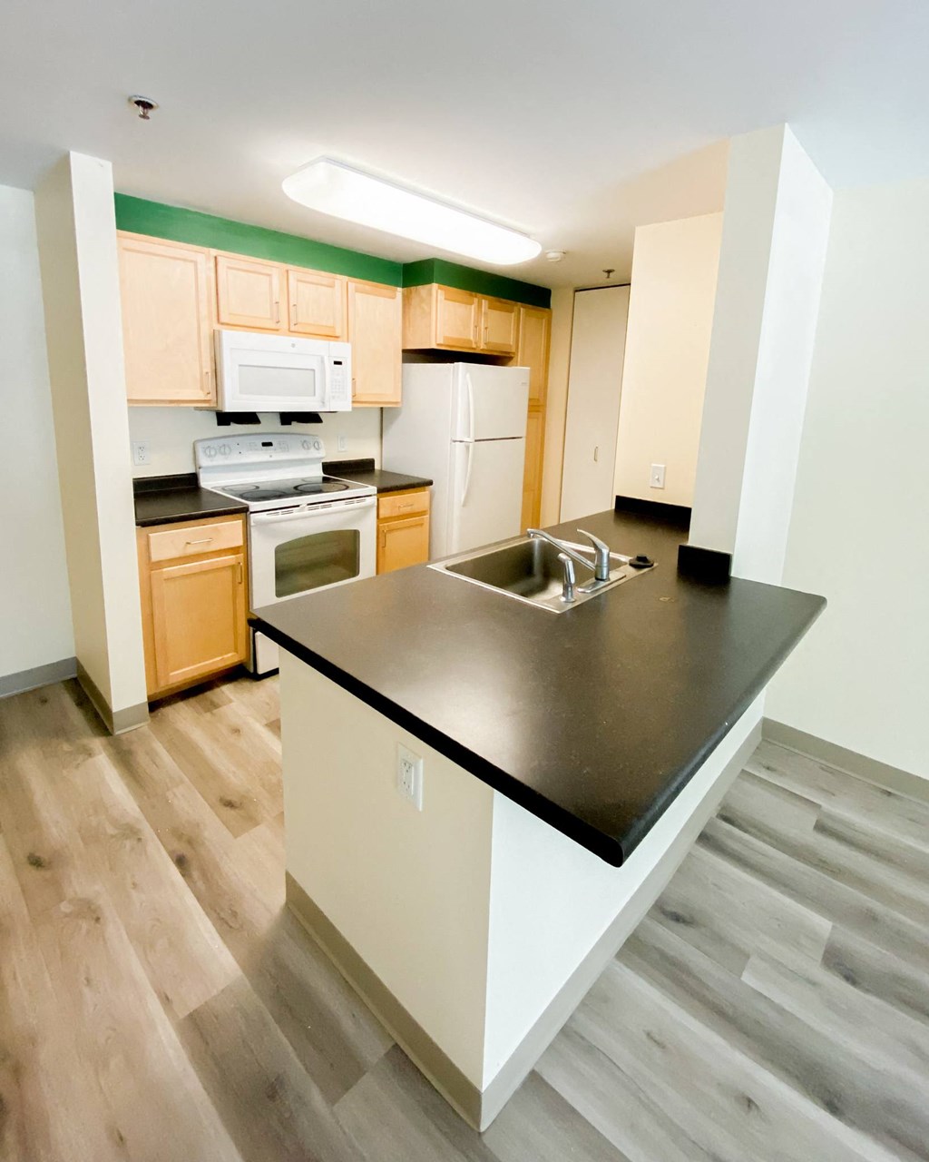a kitchen with a black counter top and a sink