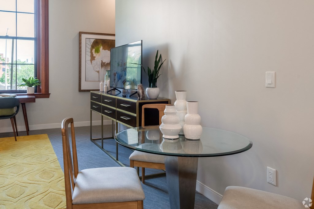 a living room with a glass table and chairs and a television