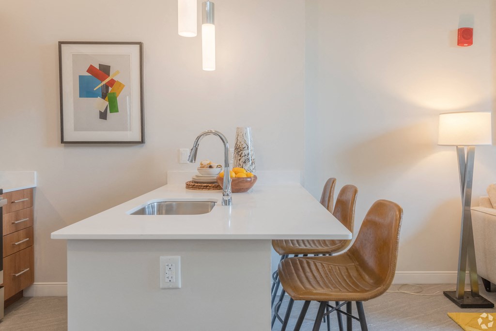a kitchen with a white counter top and a sink