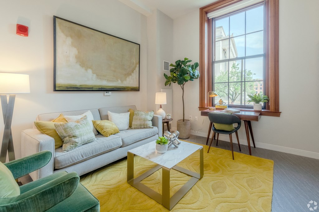 a living room with a couch and a table    and a large window