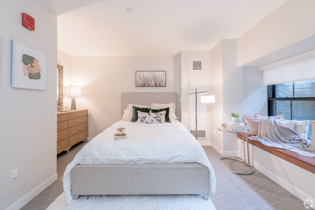 a bedroom with a bed and a dresser and a window