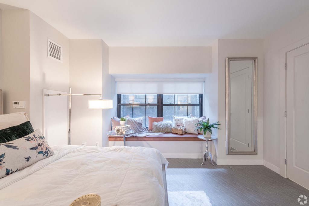 a bedroom with a bed and a window with a window seat