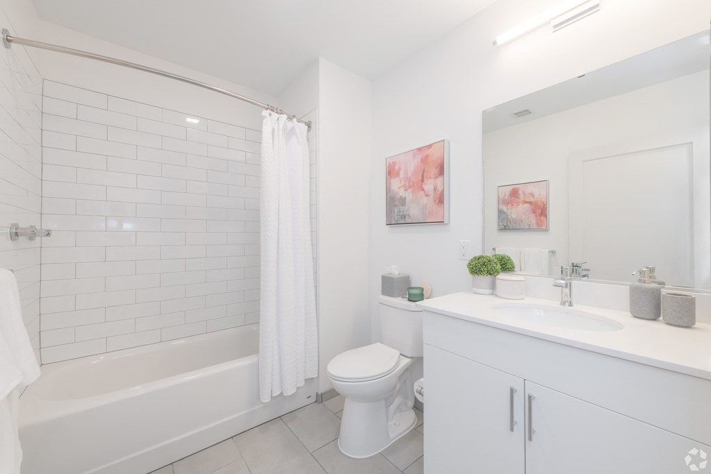 a white bathroom with a shower and a toilet and a sink
