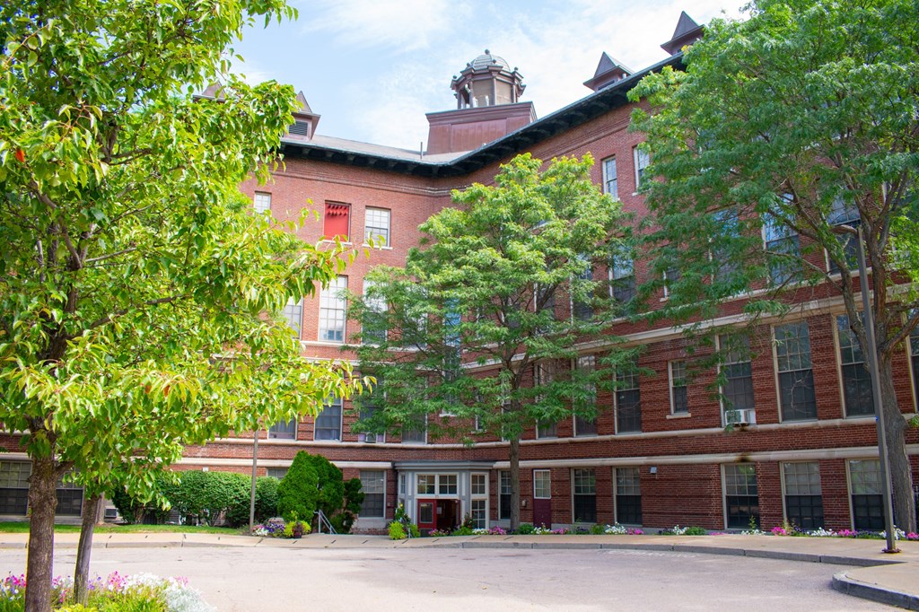 a large red brick building with trees in front of it