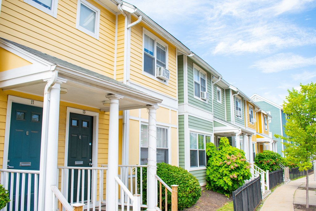 a row of houses with yellow siding and green shutters