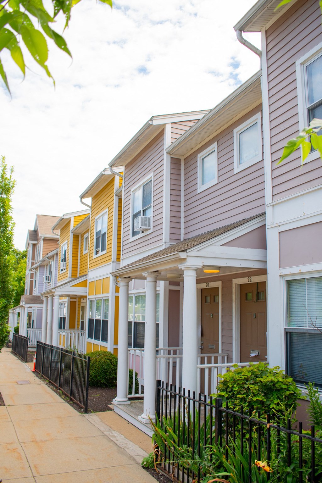 a row of townhomes with a sidewalk in front of them