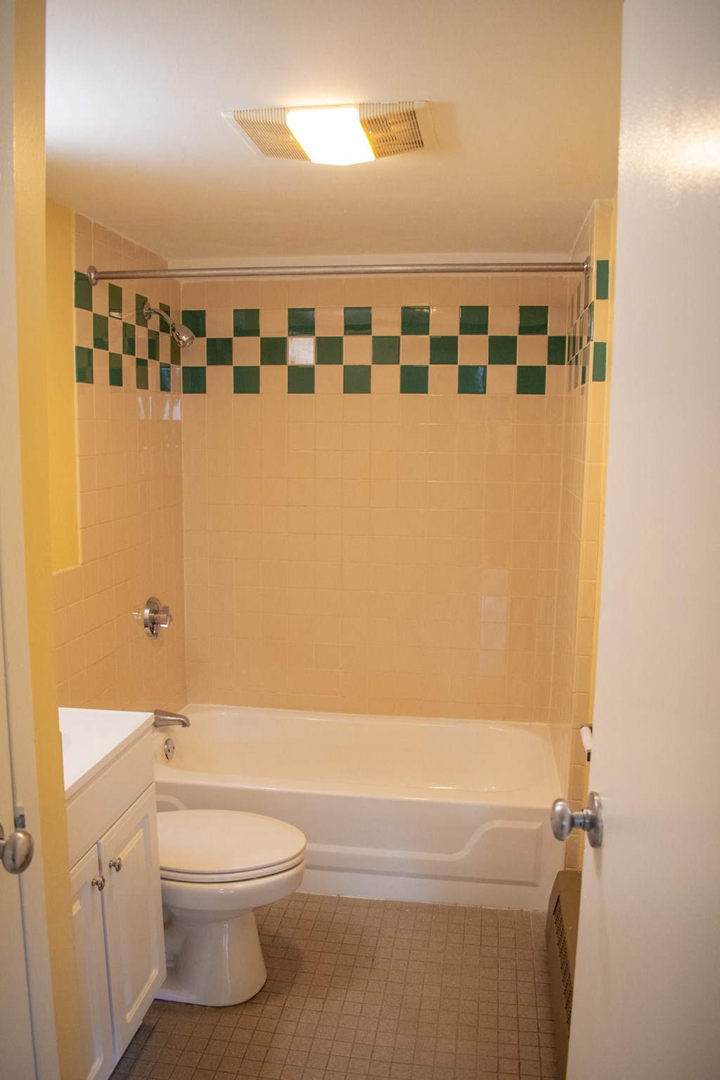 a bathroom with a white toilet next to a white bathtub