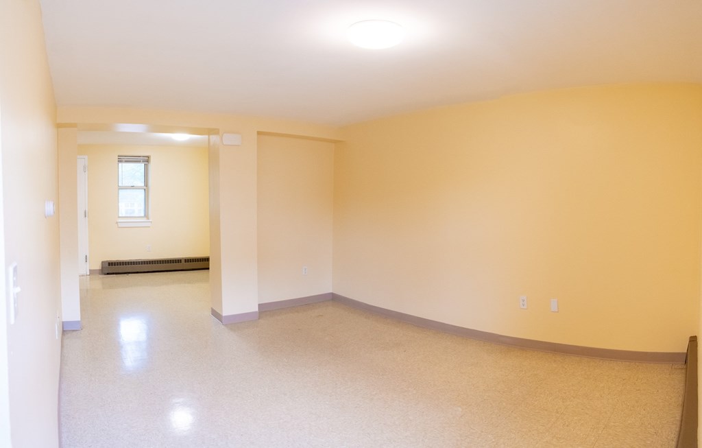 an empty room with yellow walls and white trim