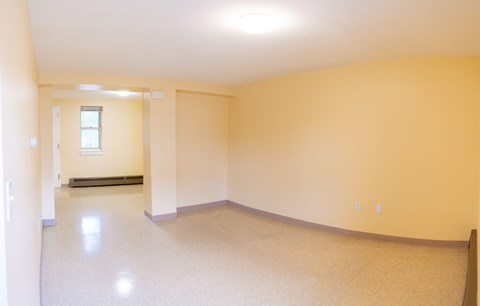 an empty living room with yellow walls and a white floor