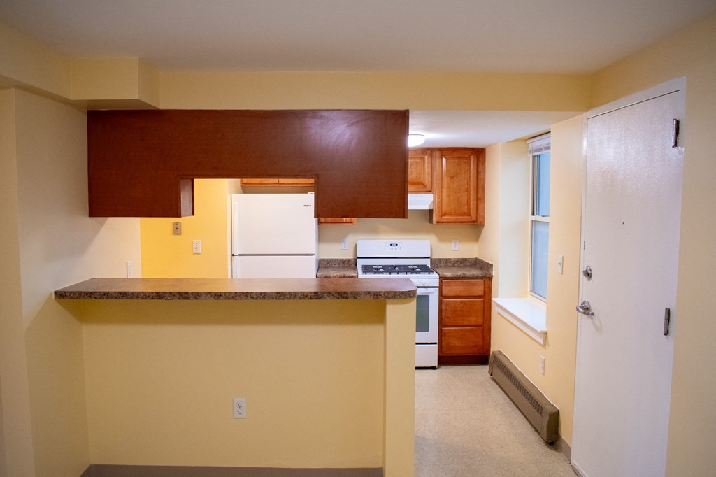 a kitchen with white appliances and wooden cabinets