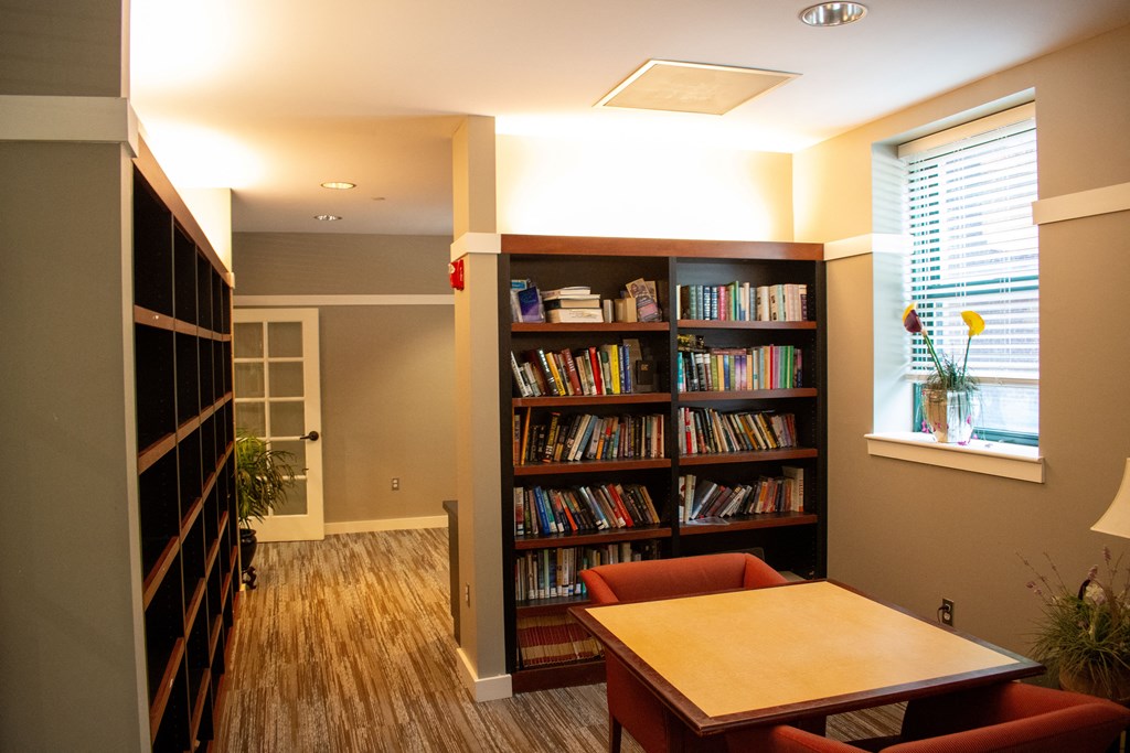 a room with a table and chairs and a bookcase filled with books
