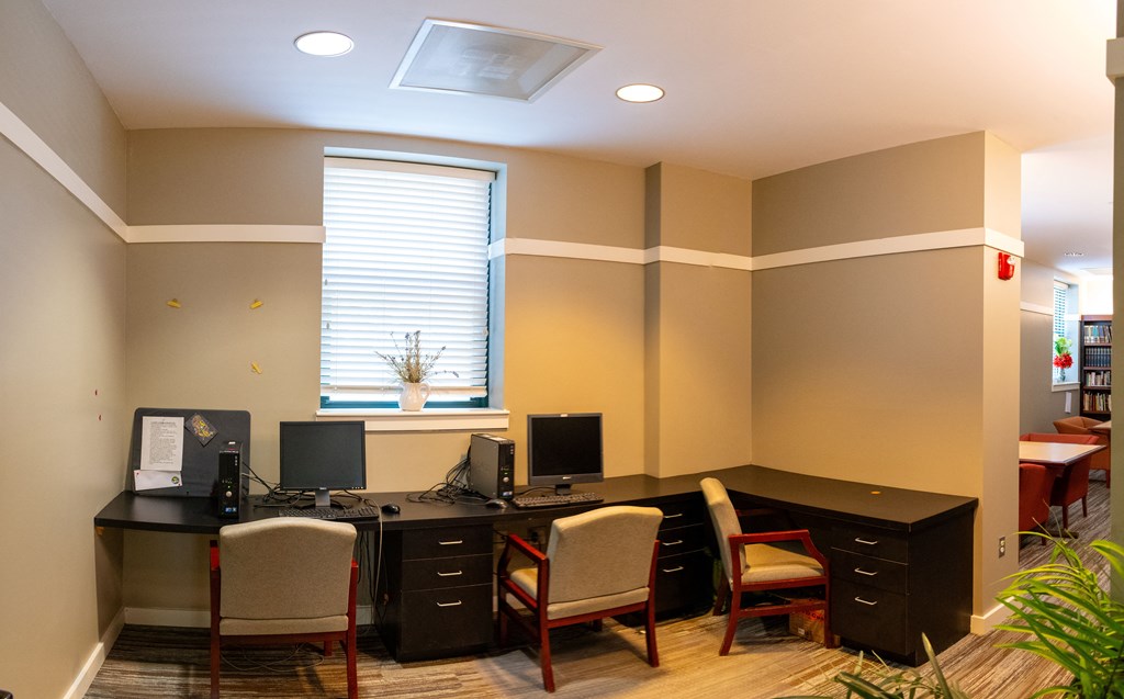 an office with two computers and four chairs