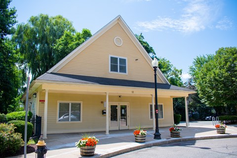 A small building with a black roof and a yellow front.