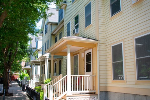 A yellow house with a white porch.