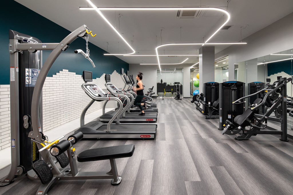 a group of people working out in a gym with cardio equipment