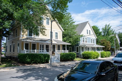 a row of houses on a street with a car parked in front of them