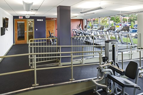 a gym with weights and cardio equipment in a building