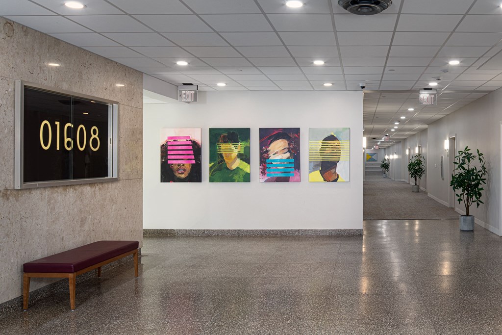 a hallway with paintings on the wall and a bench