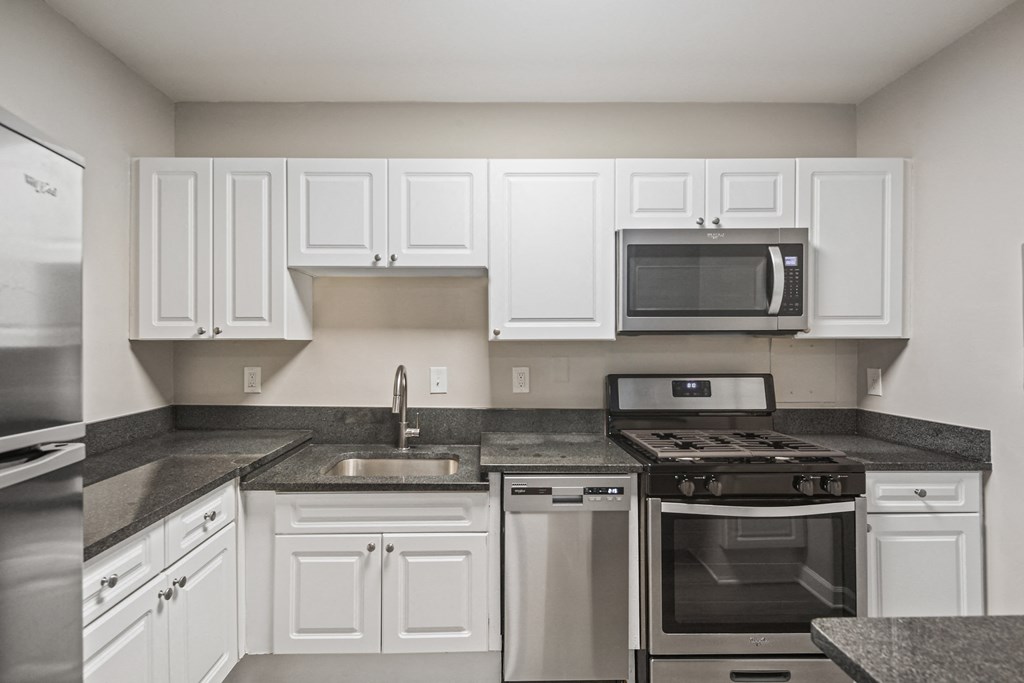 a kitchen with white cabinets and stainless steel appliances