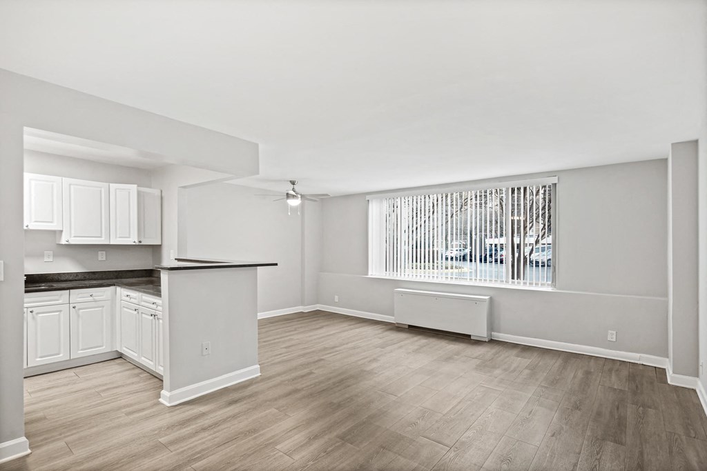 an empty living room and kitchen with a large window