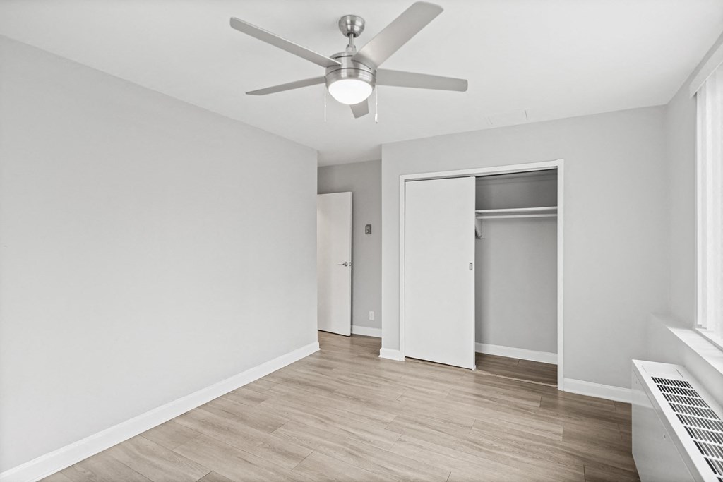 a living room with white walls and a ceiling fan