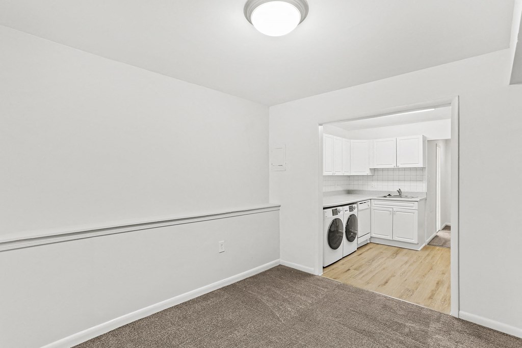 living room and kitchen with in unit laundry machines