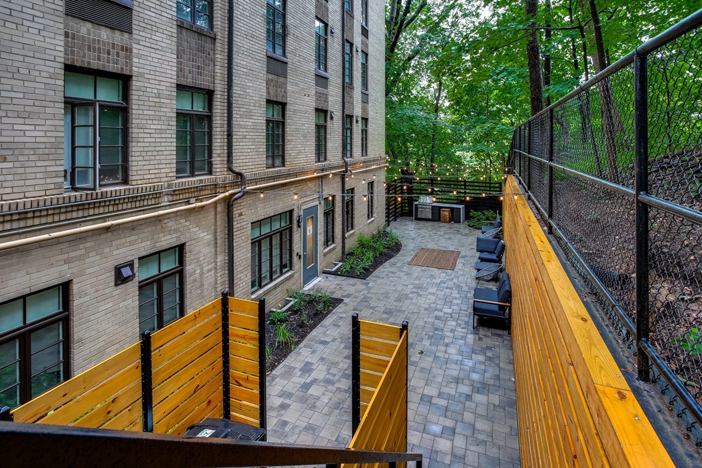 A view of a courtyard from a balcony with a black fence.