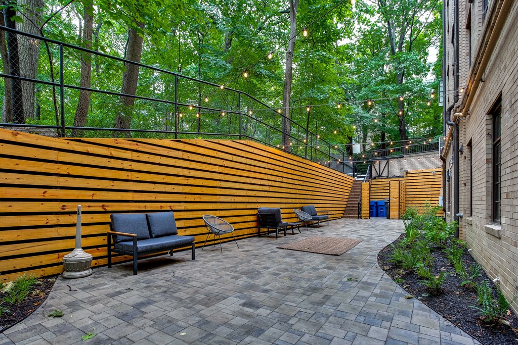 A patio with a bench and a fence.