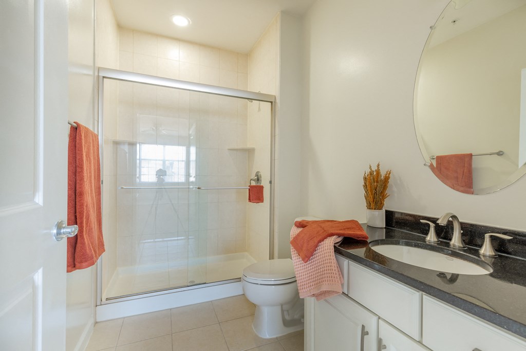 a bathroom with a shower and a sink and a toilet