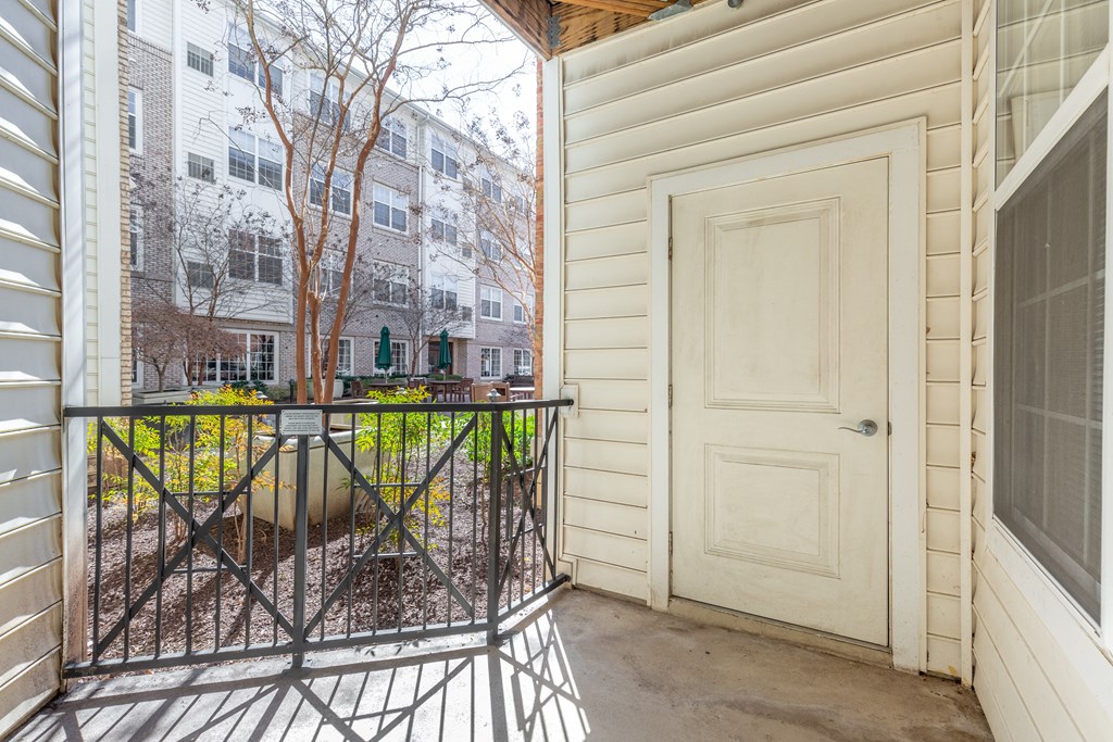 the front door of a home with a balcony and a white door