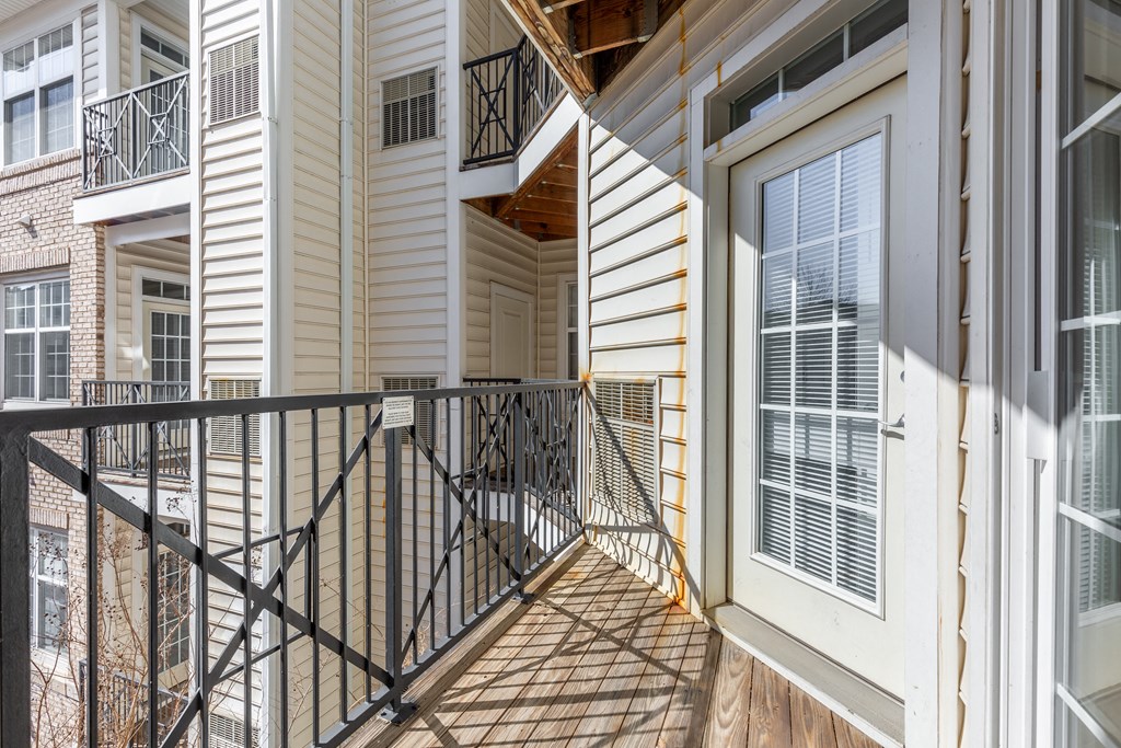 the entrance to a home with a balcony and a door to the street