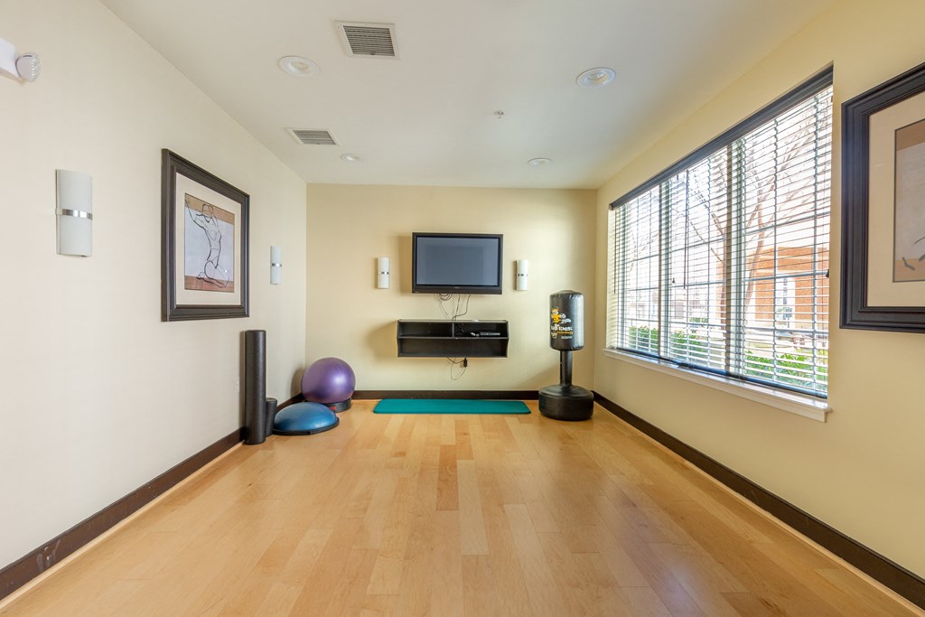 a living room with a tv on the wall and a wood floor