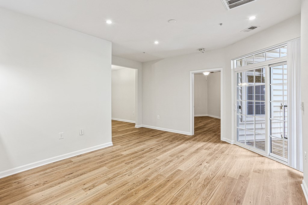 a living room with white walls and wood floors