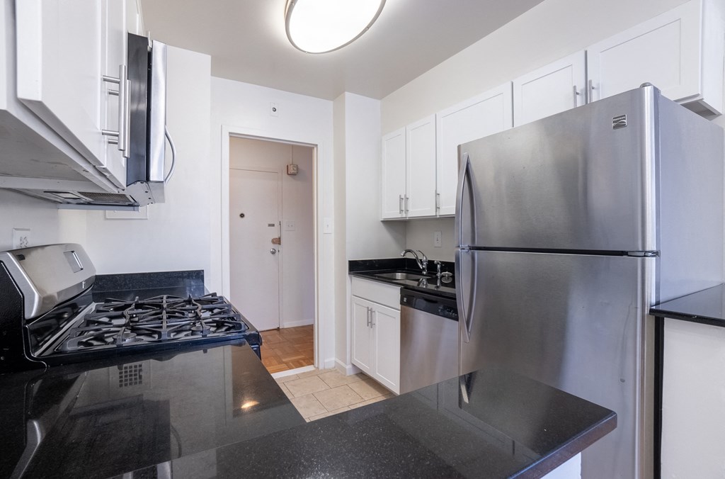 A kitchen with a stove top oven and a refrigerator.