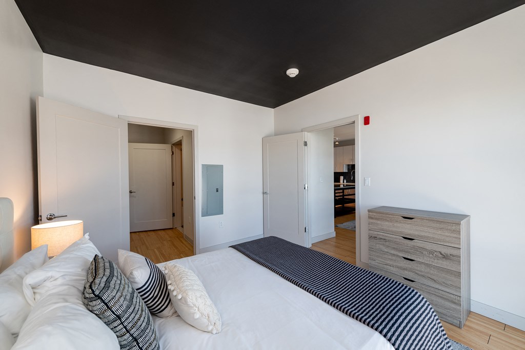a bedroom with a white bed and a black ceiling