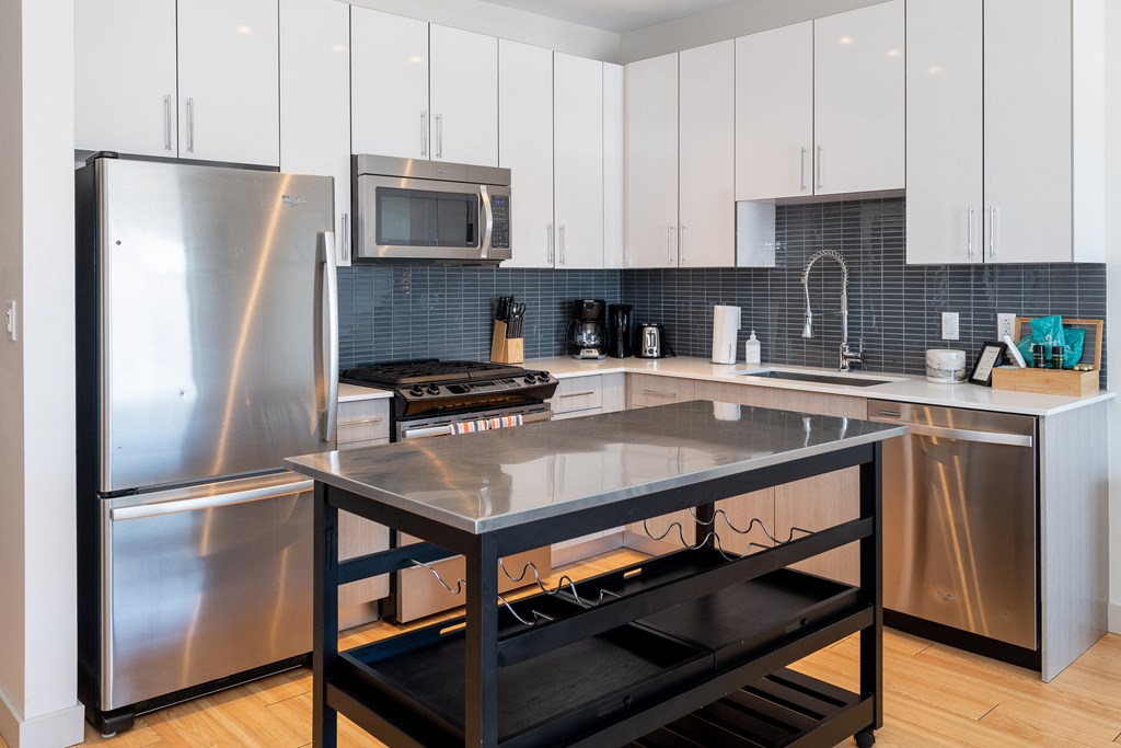 a modern kitchen with stainless steel appliances and white cabinets