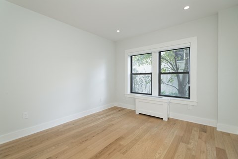 a living room with white walls and a large window