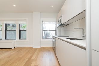 a kitchen with white cabinets and a sink and a window