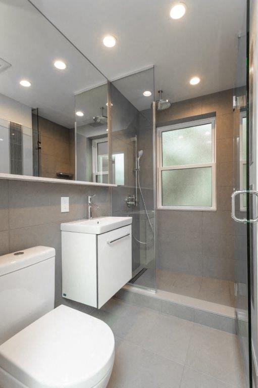 a bathroom with a toilet and a sink and a shower