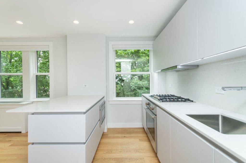 a white kitchen with a stove and a window