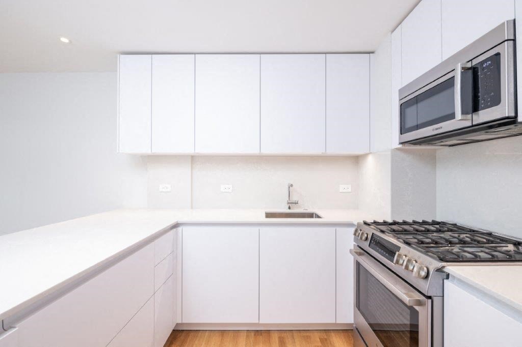 a kitchen with white cabinets and a stove and a microwave