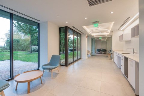 a room with a table and chairs and a large window