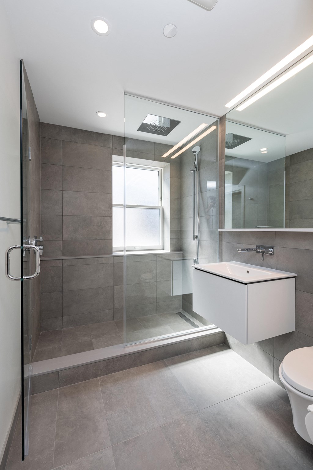 a modern bathroom with a glass shower stall and a white sink