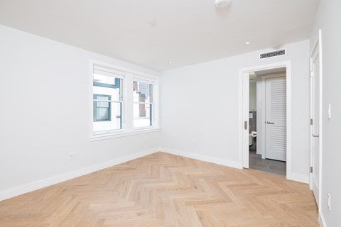a living room with a hardwood floor and white walls