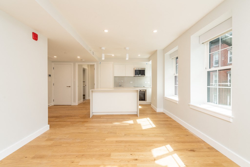 a living room and kitchen with wood floors