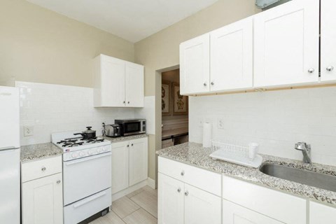 a kitchen with white appliances and granite counter tops
